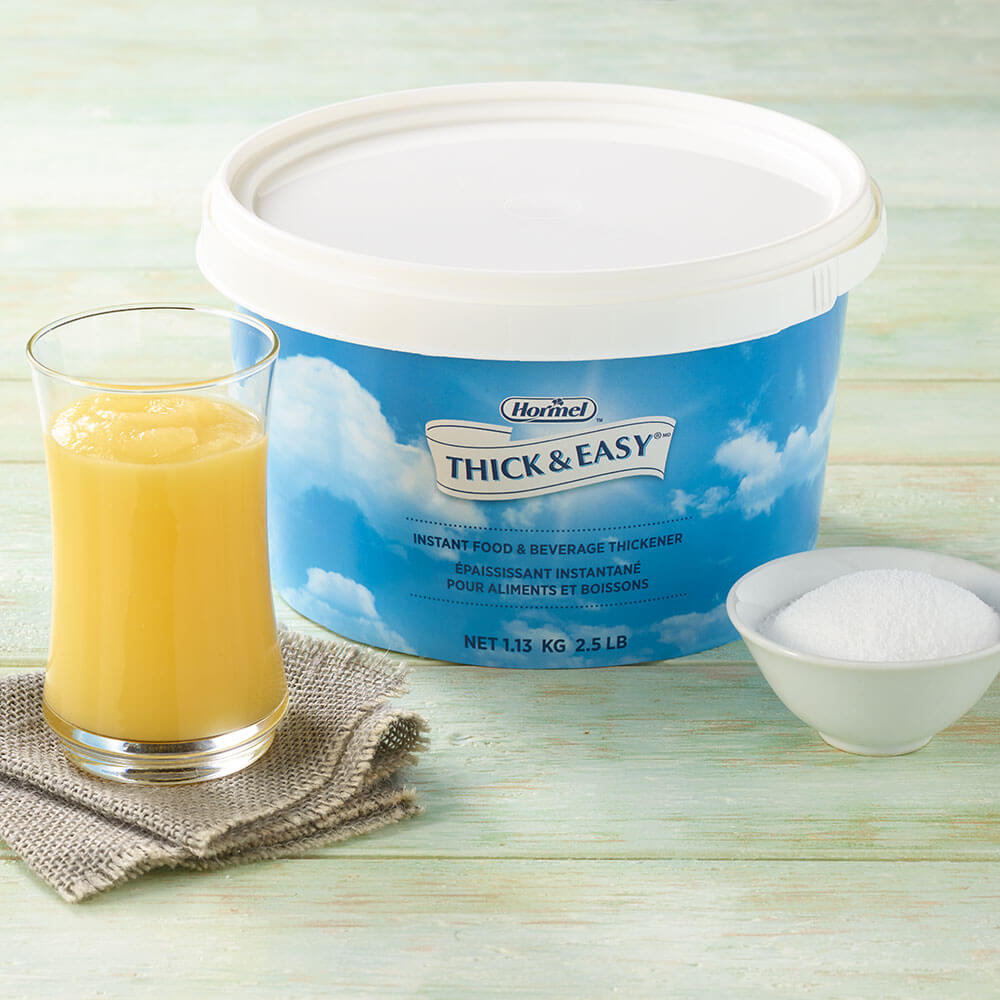 Thick and Easy Instant Thickener canister on table with thickened beverage and powder with white background