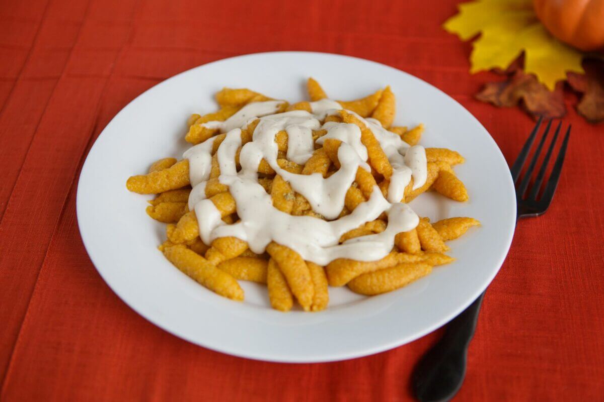 Pumpkin pasta with sauce for dysphagia diets in a white bowl