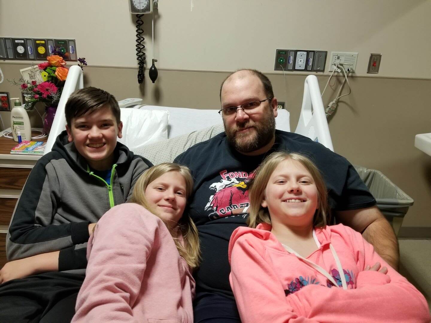 Health hero Matt Moore and family in hospital bed