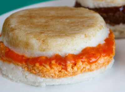 Dysphagia friendly buffalo chicken burger with bun on white plate