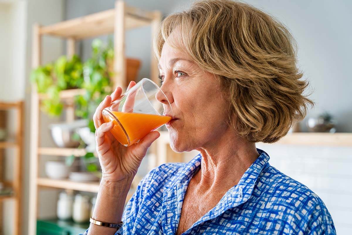 Senior woman drinking a glass of juice