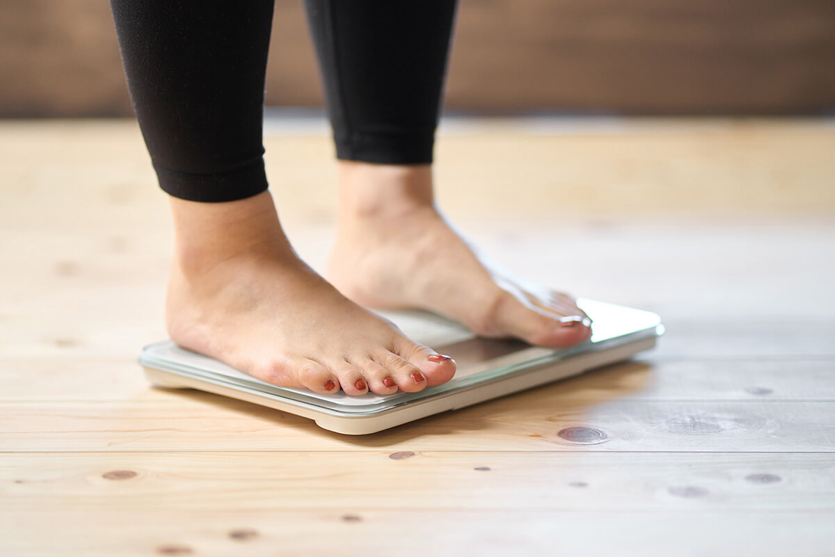 Woman stepping on scale